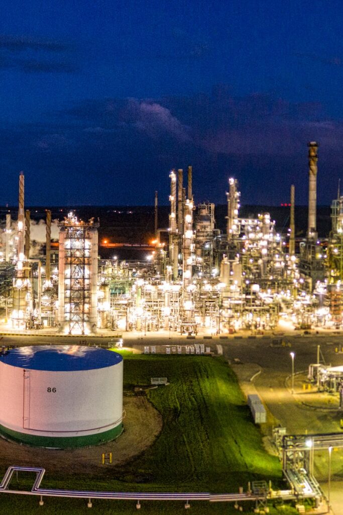 pexels-photo-10396413-10396413 Aerial night view of a brightly lit industrial oil refinery with smoking chimneys in Rosemount, MN, USA.